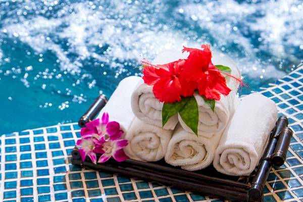 Handtücher mit roten Blumen auf dem Poolrand im Bamboo Village Beach Resort