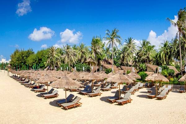 Strand des Bamboo Village Beach Resort & Spa mit vielen Sonnenliegen und Sonnenschirmen
