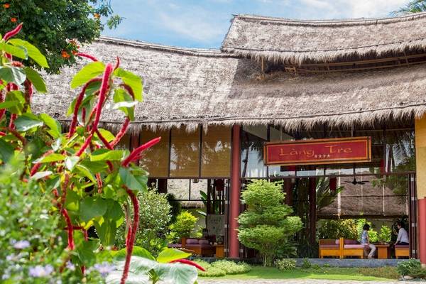 Außenansicht des Bamboo Village Beach Resort & Spa mit terrassenförmigem Eingang und Strohdach.