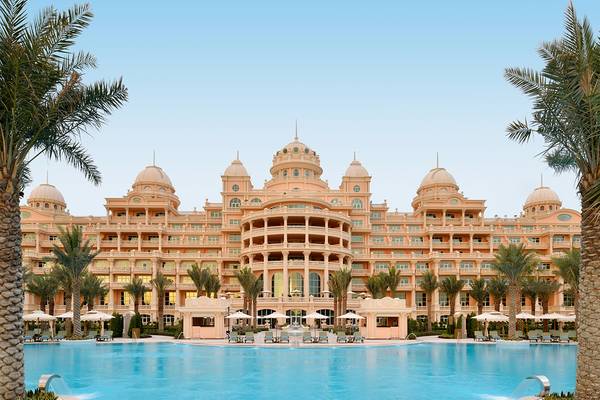 Außenansicht des Raffles The Palm Dubai Hotels mit großem Pool und üppigen Palmen