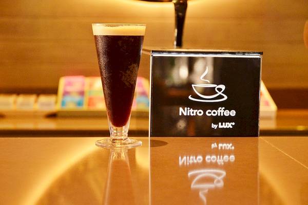 Nitro Kaffeeglas neben Nitro Kaffee Box von LUX Belle Mare Resort & Villas auf einem Tisch
