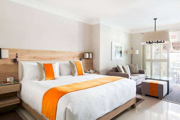 Schlafzimmer im LUX Belle Mare Resort & Villas mit Bett, Sofa und Nachttisch