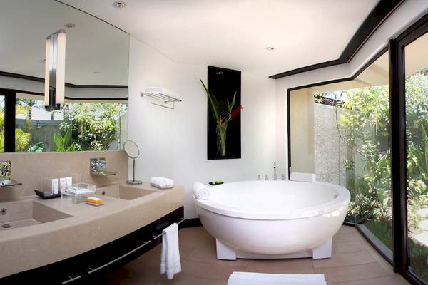 Badezimmer im LUX Belle Mare Resort & Villas mit Badewanne, Waschbecken und Dusche.