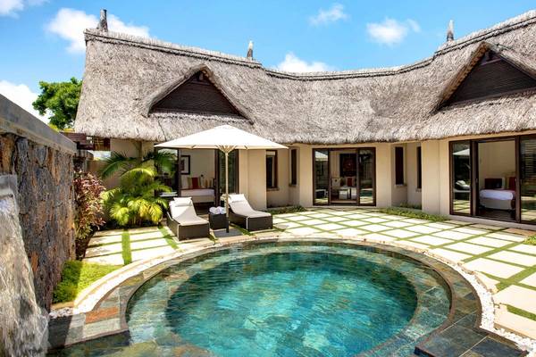 Außenbereich der Villa mit Swimmingpool und Sonnenliegen im LUX Belle Mare Resort & Villas.