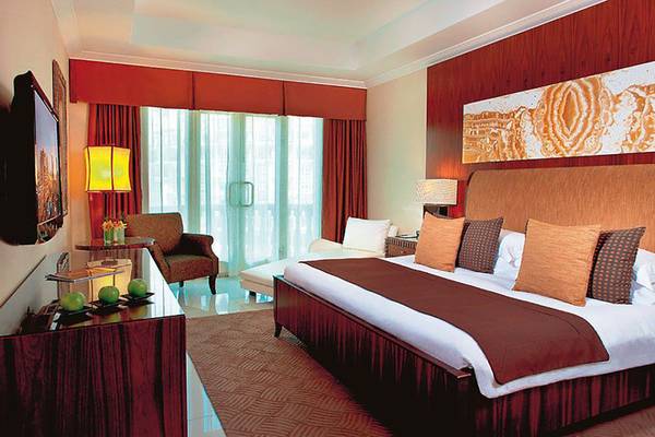 Suite Zimmer im Swissotel Al Murooj Dubai mit großem Bett, Fernseher, und Aussichtsfenster.