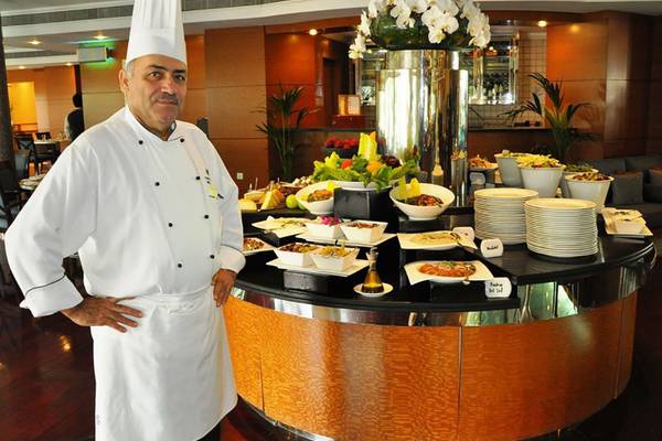 Ein Koch steht vor einem Buffettisch im Swissotel Al Murooj Dubai.