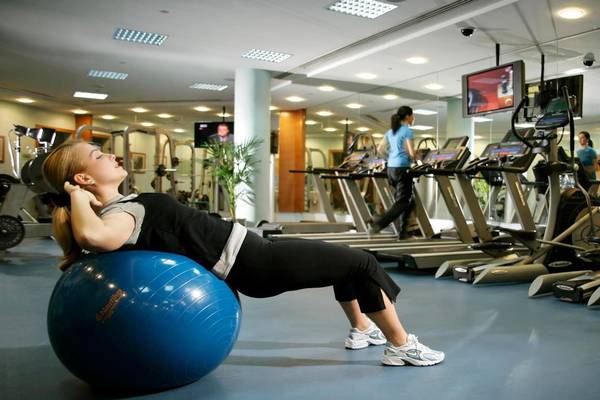 Frau im Fitnessstudio mit einem blauen Trainingsball im Swissotel Al Murooj Dubai