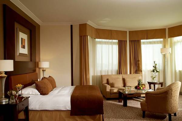 Doppelbettzimmer im Swissotel Al Murooj Dubai mit bequemen Möbeln und Ausblick.