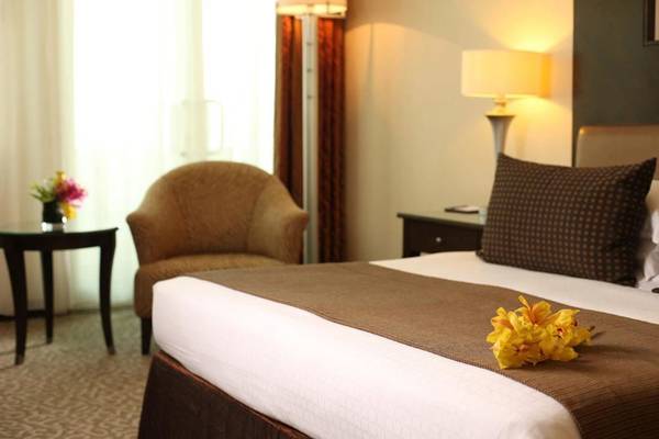 Doppelbett mit gelben Blumen im Zimmer im Swissotel Al Murooj Dubai