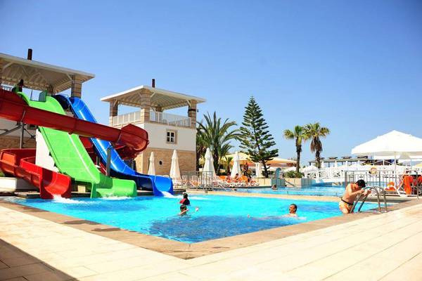 Schwimmbadbereich im Orange County Belek - Family Concept Hotel mit bunten Wasserrutschen und Kindern, die spielen.