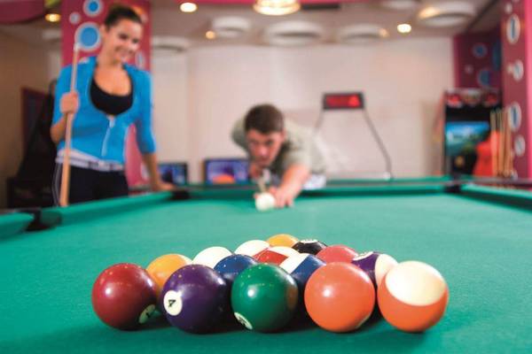 Mann spielt Billard im Hotel Orange County Belek, Frau schaut zu.