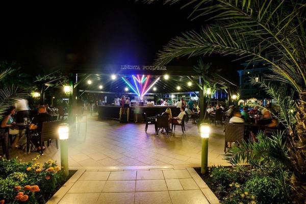 Pool-Bar des Orange County Belek - Family Concept Hotels bei Nacht mit bunten Lichtern und Gästen.