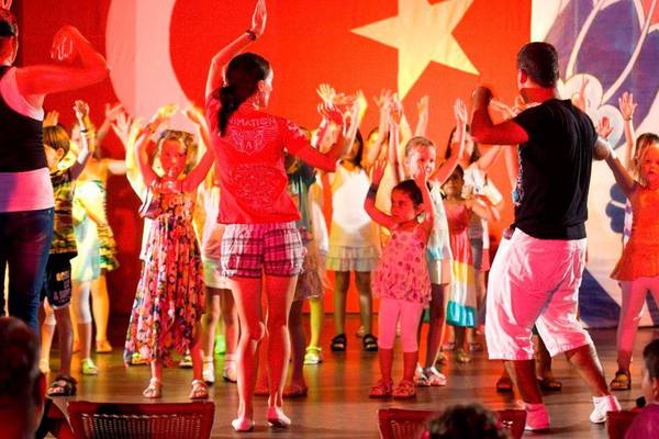 Gruppe von Kindern und Erwachsenen tanzt auf der Bühne im Hotel.