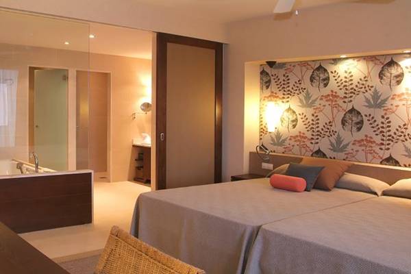 Hotelzimmer im Barcelo Tenerife mit Doppelbett, Glasdusche und Nachttisch.