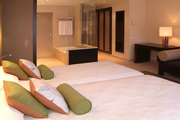 Schlafzimmer im Barcelo Tenerife Hotel mit zwei Betten und angrenzendem Badezimmer.