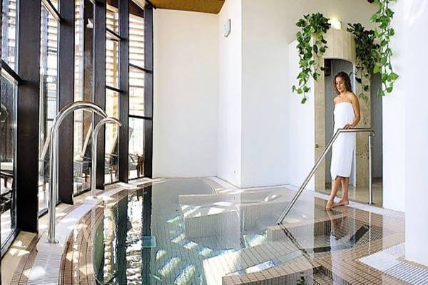 Eine Frau im weißen Handtuch steht neben dem Innenpool im Barcelo Tenerife Hotel.