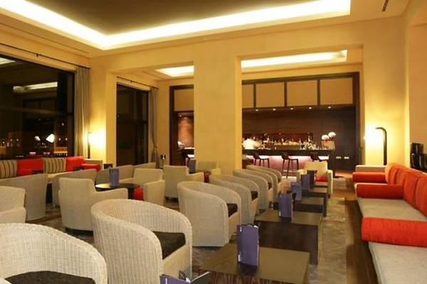 Loungebereich des Barcelo Tenerife Hotels mit Sesseln, Tischen und einer Bar im Hintergrund.