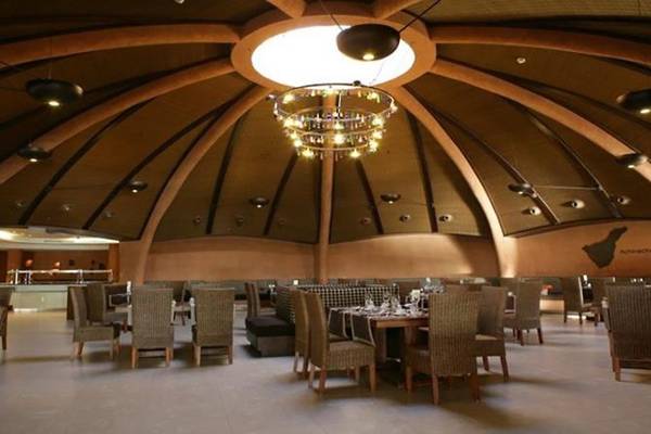 Innenansicht des Restaurants im Barcelo Tenerife Hotel mit vielen Tischen und Stühlen, einer großen Kronleuchter und einer gewölbten Decke.
