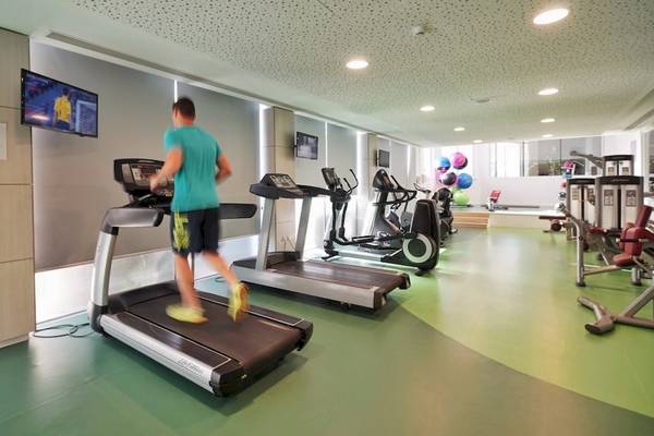 Fitnesscenter im Melissi Beach Hotel & Spa mit einem Mann, der auf einem Laufband läuft.