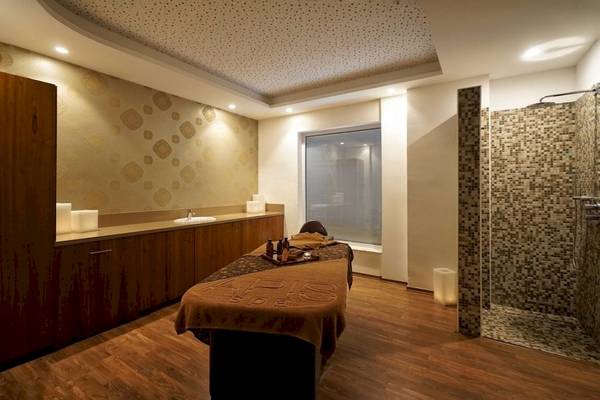 Behandlungsraum im Melissi Beach Hotel & Spa mit Therapietisch, Holzboden und Dusche