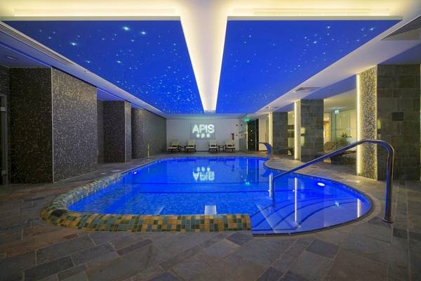 Innenpool des Melissi Beach Hotel & Spa mit blau beleuchteter Decke und Wasser