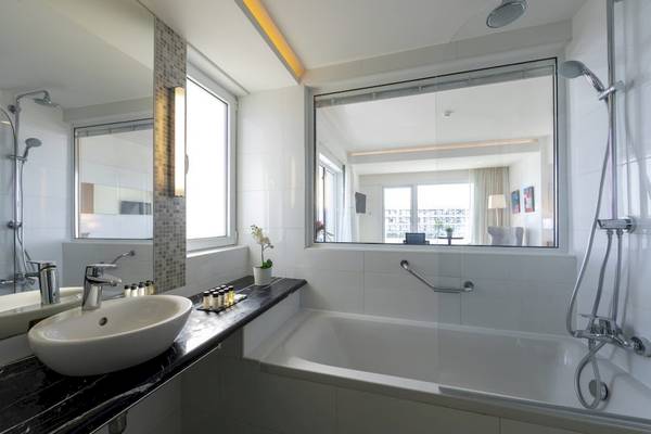 Badezimmer des Melissi Beach Hotel & Spa mit Badewanne und Dusche, Waschbecken und Spiegeln