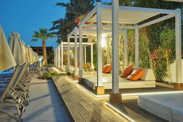Terrasse des Melissi Beach Hotel & Spa bei Nacht mit Loungebetten und Pflanzen