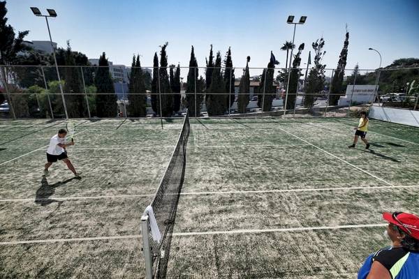 Tennisplatz im Freien mit Spielern und Zuschauern im Hintergrund beim Melissi Beach Hotel & Spa.