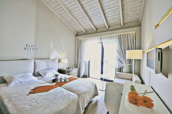 Zimmer im Aegean Pearl Hotel mit zwei Betten, einem Schreibtisch und einer Terrasse.