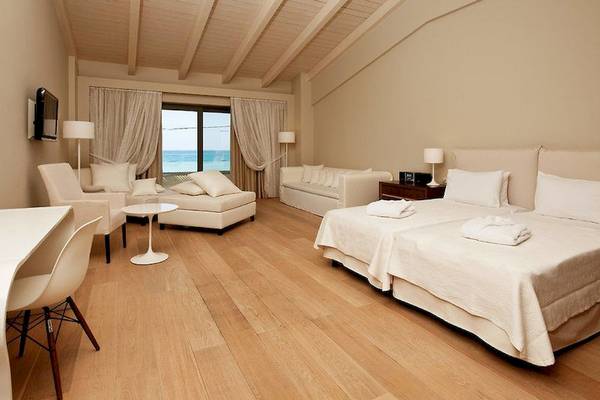 Schlafzimmer im Aegean Pearl Hotel mit zwei Betten, weißer Möbel und Meerblick.