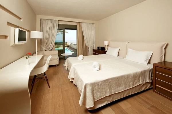 Doppelzimmer im Aegean Pearl Hotel mit Meerblick, zwei Betten, Tisch und Sessel