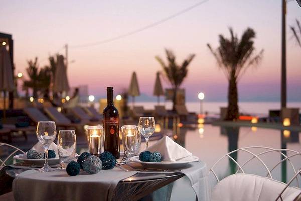 Romantisches Dinner am Pool im Aegean Pearl Hotel mit Blick auf das Meer und die Dämmerung.