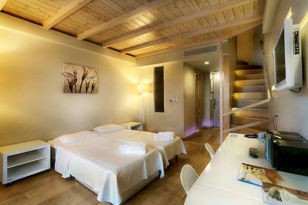 Doppelzimmer im Aegean Pearl Hotel mit zwei Betten, Schreibtisch und Fernseher.