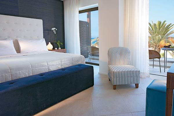 Innenansicht eines eleganten Zimmers im Amirandes Grecotel Boutique Resort mit Blick auf das Meer.