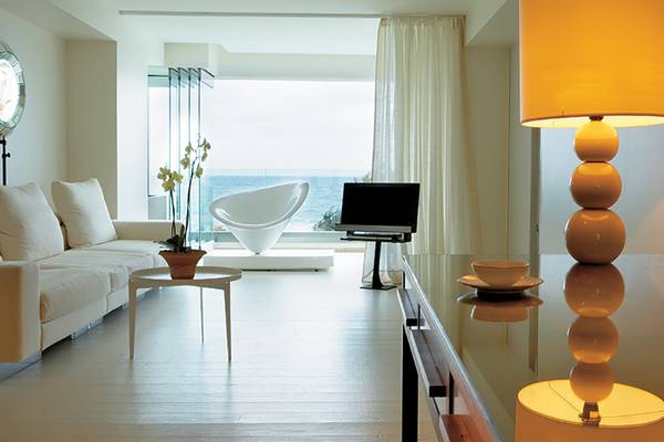 Wohnbereich des Amirandes Grecotel Boutique Resorts mit Meerblick, Couch, Tisch und Lampen.