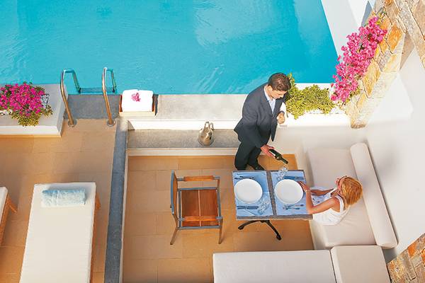 Ein Paar genießt ein Abendessen am Pool im Amirandes Grecotel Boutique Resort.
