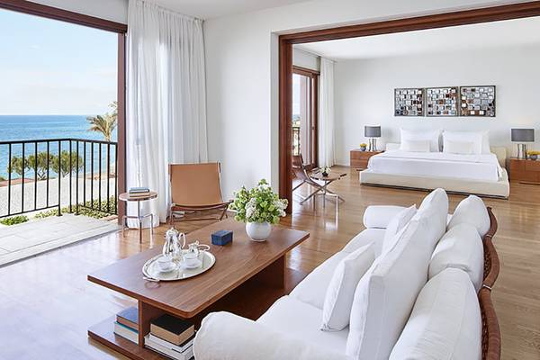 Ein elegantes Zimmer im Amirandes Grecotel Boutique Resort mit Blick auf das Meer und moderner Einrichtung.