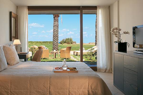 Schlafzimmer des Amirandes Grecotel Boutique Resort mit Panoramafenster und Blick auf die Landschaft
