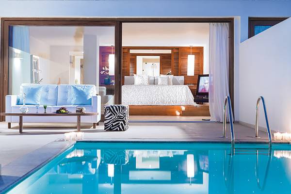Ein modernes Zimmer im Amirandes Grecotel Boutique Resort mit direktem Zugang zu einem Pool.