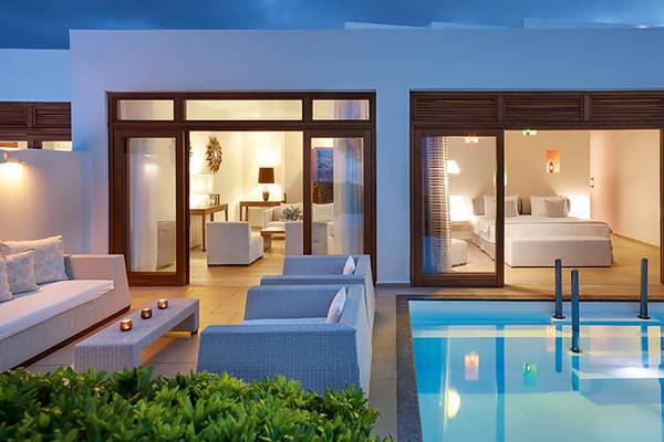 Außenansicht des Amirandes Grecotel Boutique Resorts mit Suite, Swimmingpool und Loungebereich.