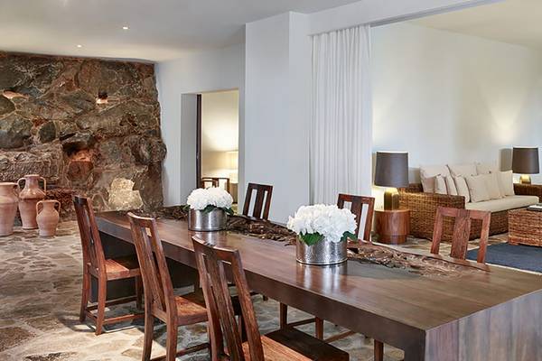 Innenbereich des Amirandes Grecotel Boutique Resort mit Esstisch, Stühle und Wohnzimmermöbel.