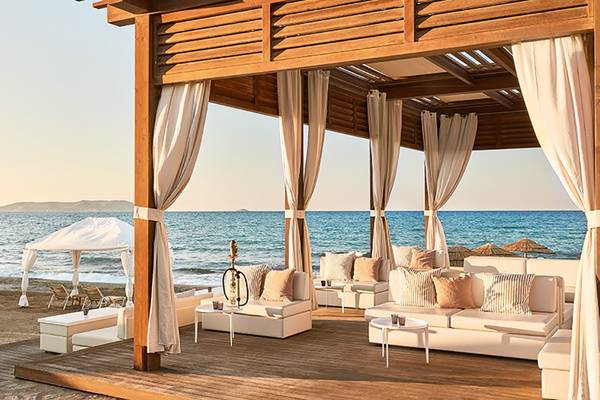 Außenbereich des Amirandes Grecotel Boutique Resorts mit Lounge-Sesseln und Meerblick.