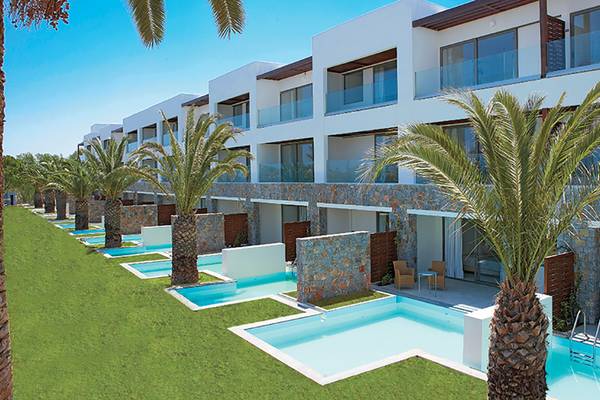 Außenbereich des Amirandes Grecotel Boutique Resorts mit Reihen von Gebäuden, Swimmingpools und Palmen.