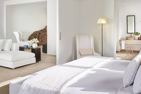 Schlafzimmer im Amirandes Grecotel Boutique Resort mit weißen Möbeln und Dekor.
