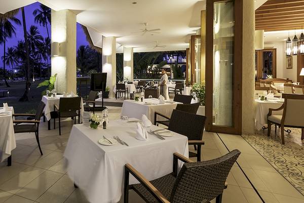 Terrassenrestaurant des Kantary Beach Hotel, Villas & Suites mit Blick auf den Ozean und Palmen