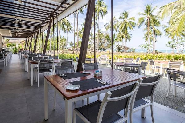 Außenterrasse des Kantary Beach Hotel, Villas & Suites mit Tischen und Stühlen, Blick auf den Ozean