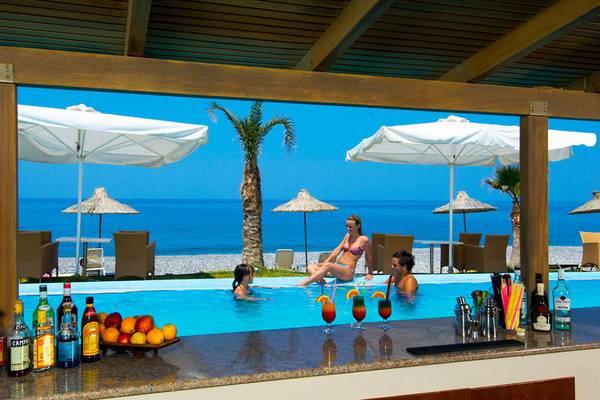 Familie im Pool des Giannoulis Grand Bay Beach Resort mit Getränken und Früchten