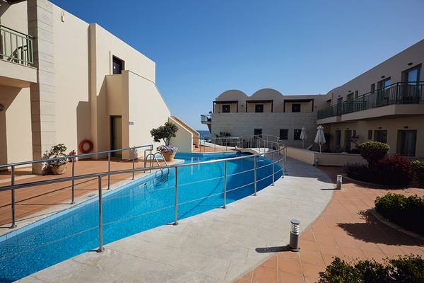 Außenpoolbereich des Giannoulis Grand Bay Beach Resorts mit blauem Wasser und geometrischen Mustern.