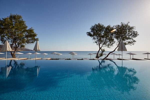 Außenpool des Giannoulis Grand Bay Beach Resort mit Sonnenschirmen und Blick auf den Strand