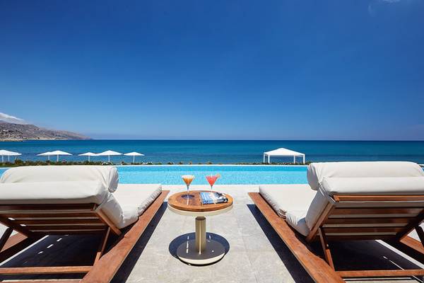 Gianoulis Grand Bay Beach Resort Pool-Lounge mit Meerblick und Cocktails auf einem Tisch